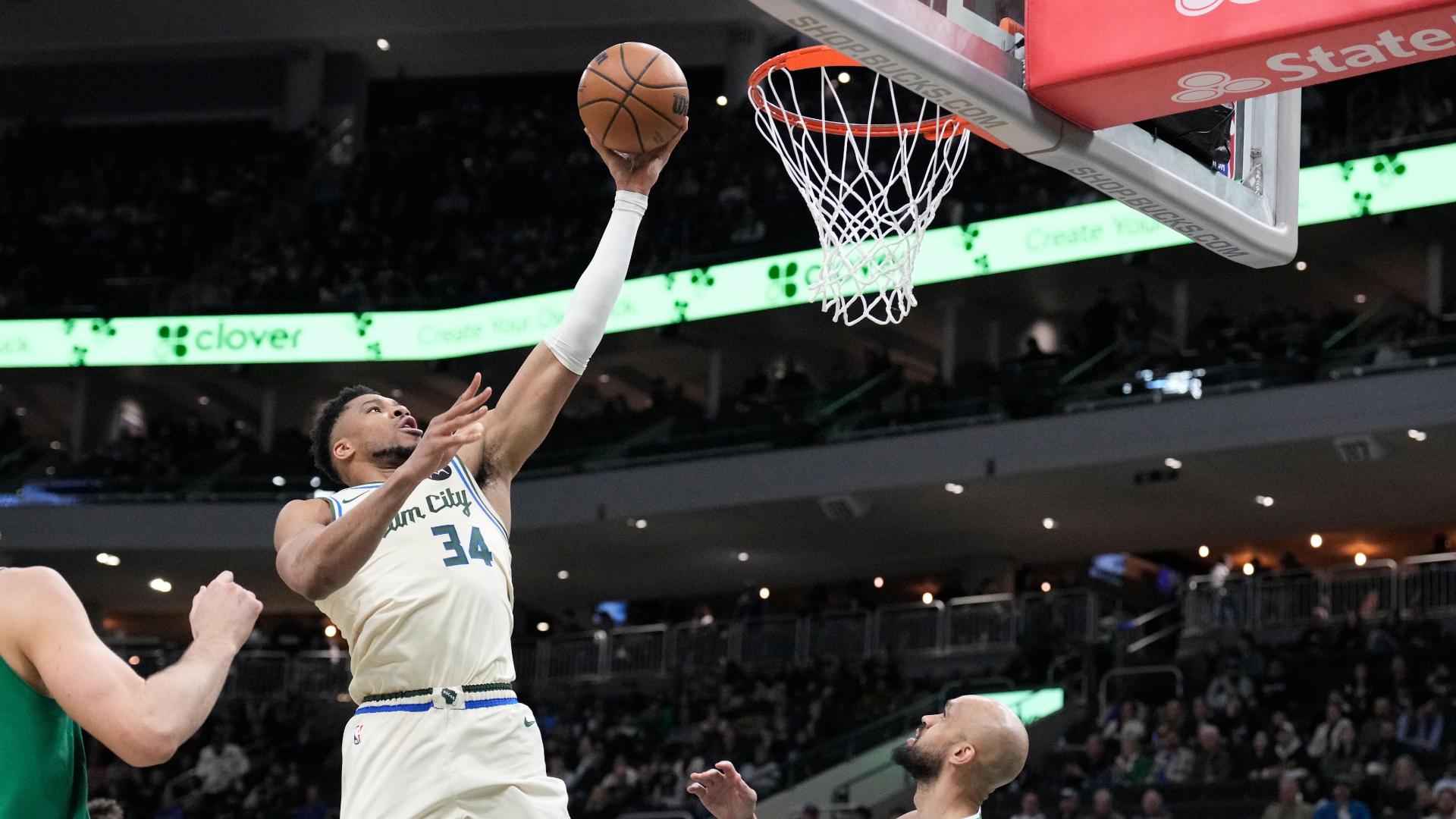Giannis Antetokounmpo dribbles though the lane and dunks over a defender early for the Bucks. 
