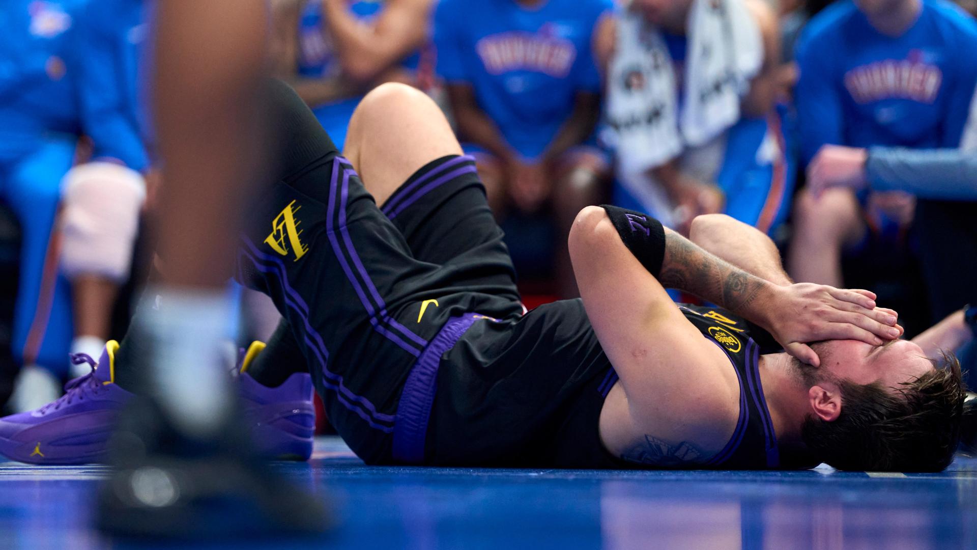 Luka Doncic goes down holding his hamstring and has to exit the game in the third quarter.