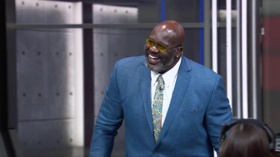 Shaquille O'Neal takes a minor fall walking over to the big screen racing Kenny Smith.