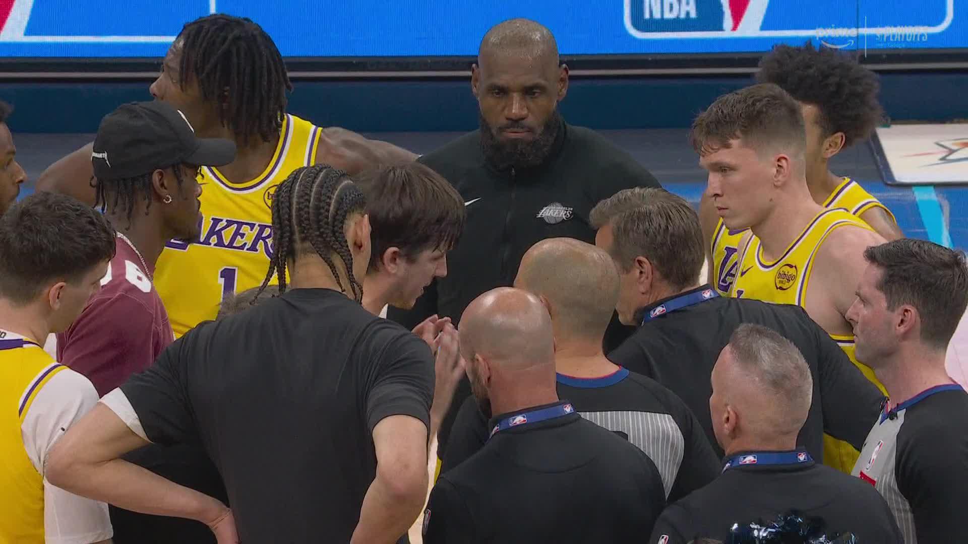 The Lakers huddle around the refs after final buzzer