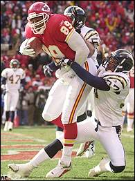 Priest Holmes of the Kansas City Chiefs runs the ball past Jason