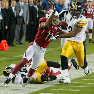 Pittsburgh Steelers linebacker James Harrison scores over Arizona Cardinals  wide receiver Larry Fitzgerald and Steve Breaston (15) on a Super Bowl  record 100-yard interception returned for a touchdown during the second  quarterat