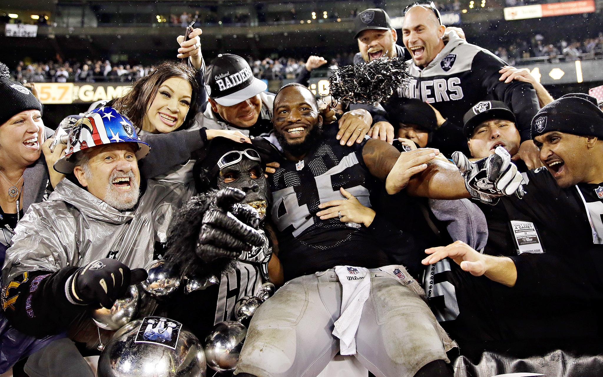 The Raiders' Marcel Reece celebrates with fans in the Black Hole after...