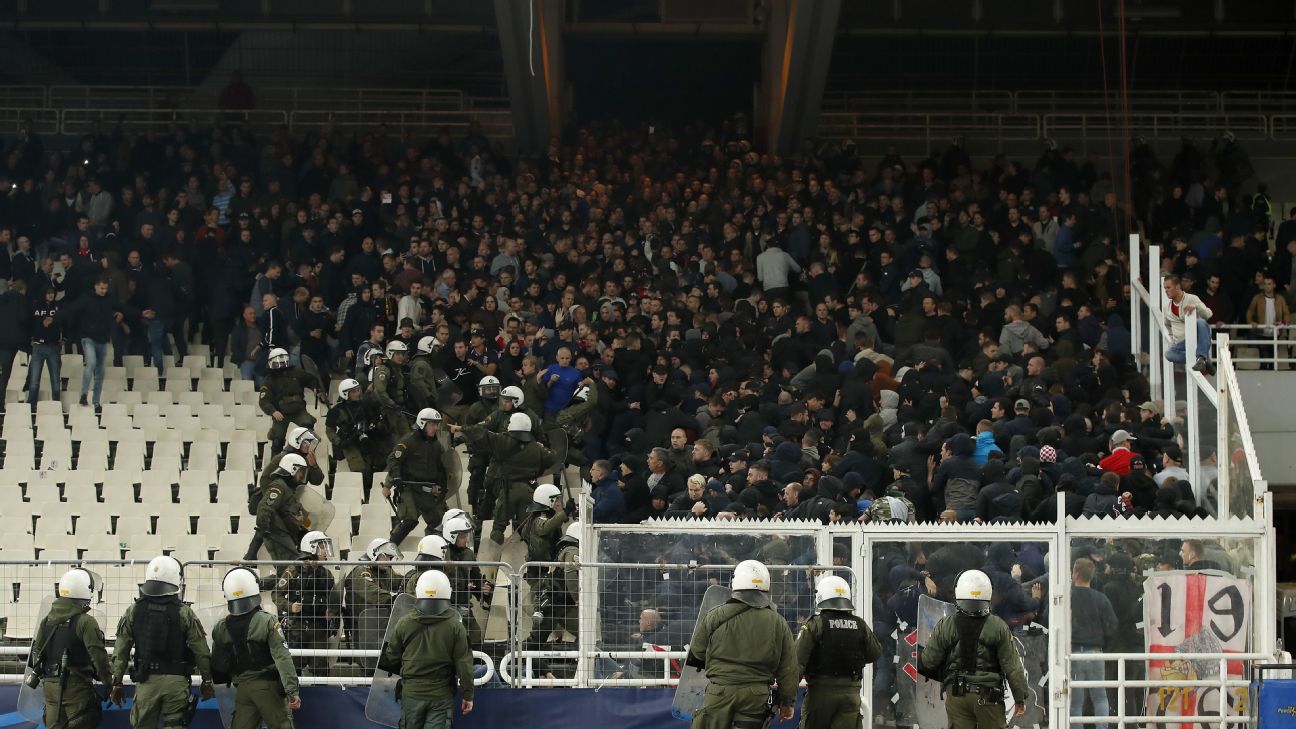 Riot police and Ajax supporters clash in the stands in Athens during Ajax's Champions League match with AEK Athens.