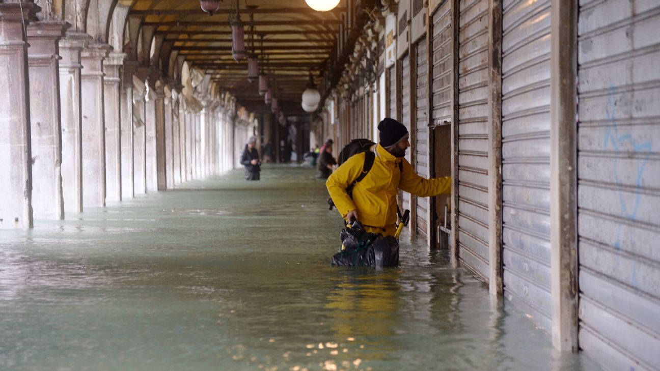 A man stands near a closed shop in St. Mark's Square during the flooding in Venice. A man stands near a closed shop in St. Mark's Square during the flooding in Venice.
