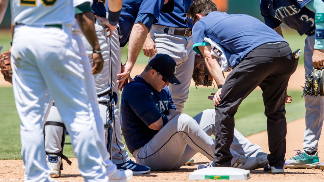 Seattle Mariners first baseman Ty France, right, grabs the hat of