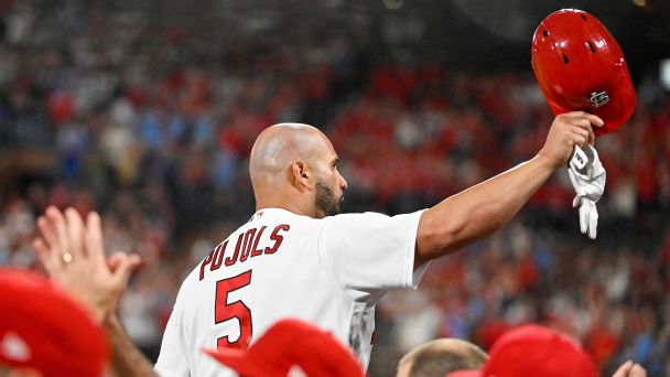 St. Louis Cardinals Albert Pujols, left, hoists his trophy for