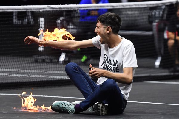 Protester sets arm on fire, disrupts Laver match
