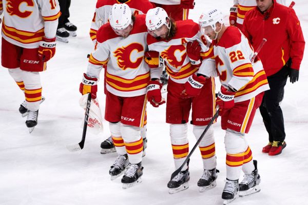 Flames' Tanev helped off after slap shot to head