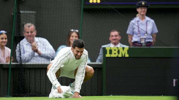 Novak Djokovic helps out during Wimbledon rain delay