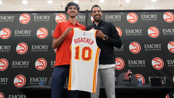 Atlanta Hawks' Zaccharie Risacher, left, and general manager Landry Fields, right, hold up Risacher's jersey after an NBA basketball news conference, Friday, June 28, 2024, in Atlanta.  [608x342]