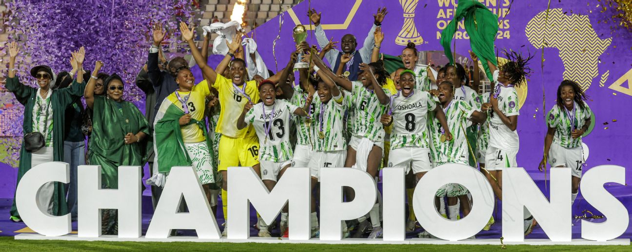 Nigeria's players celebrate with the trophy on the podium after winning the 2025 Women's Africa Cup of Nations final football match against Morocco at Prince Moulay Abdellah Stadium in Rabat on July 26, 2025