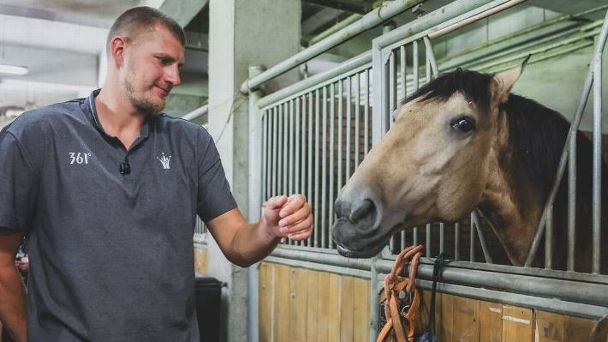 Denver Nuggets star Nikola Jokic tends to a horse while in China.