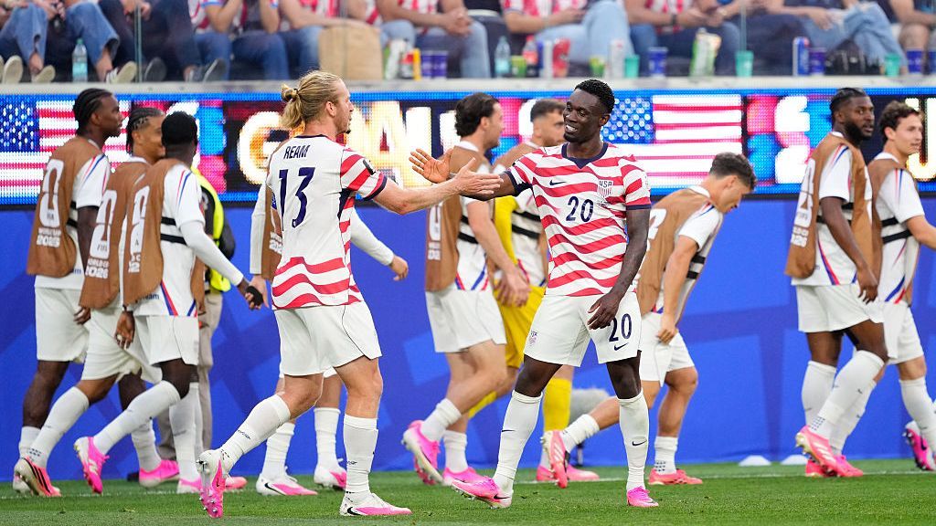 USMNT players celebrate after scoring a goal against Paraguay at the World Cup.