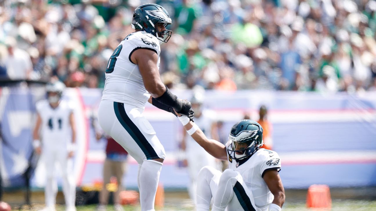 Jordan Mailata helps Eagles QB Jalen Hurts up from the turf on a sweltering day at Nissan Stadium in Nashville. — Article image accompanying Nashville turf temp of 157 F melts cleats, sends Sirianni for IV on WagerUp Sports News. Jordan Mailata helps Eagles QB Jalen Hurts up from the turf on a sweltering day at Nissan Stadium in Nashville. — Article image accompanying Nashville turf temp of 157 F melts cleats, sends Sirianni for IV on WagerUp Sports News.